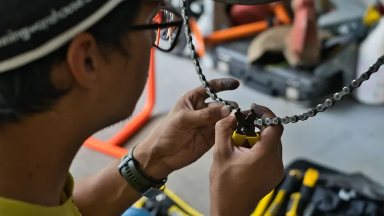 Cyclist using a chain tool to carry out basic bike maintenance
