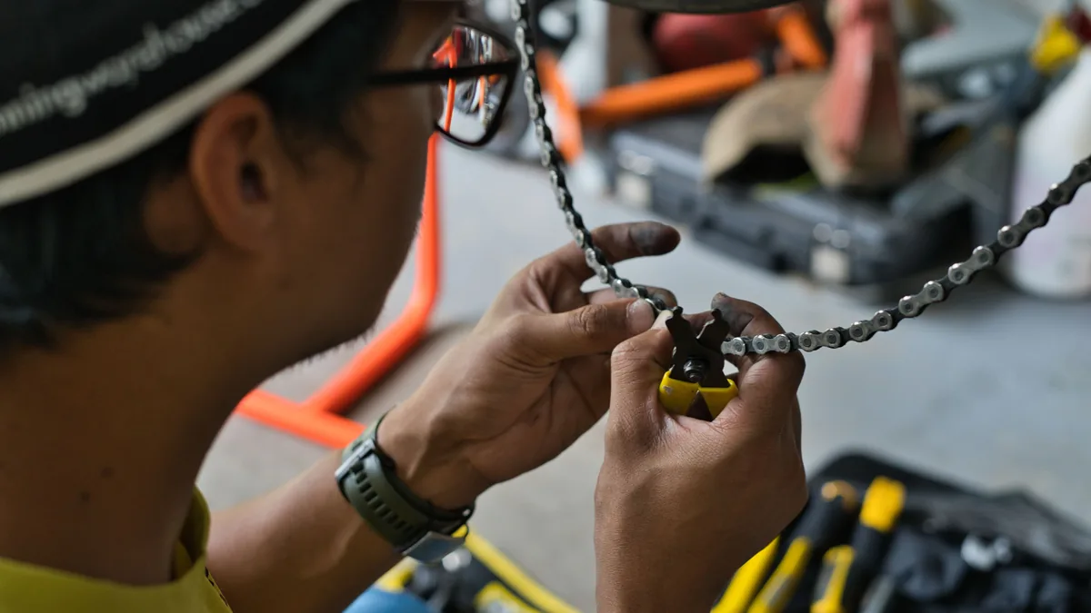 Cyclist using a chain tool to carry out basic bike maintenance
