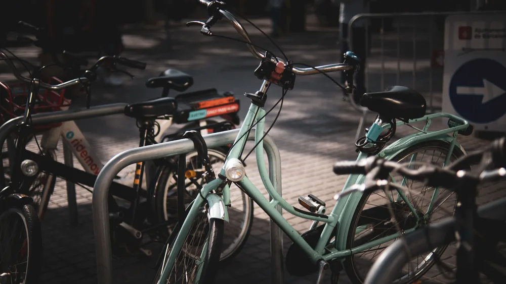 A bicycle locked to a rack in the city