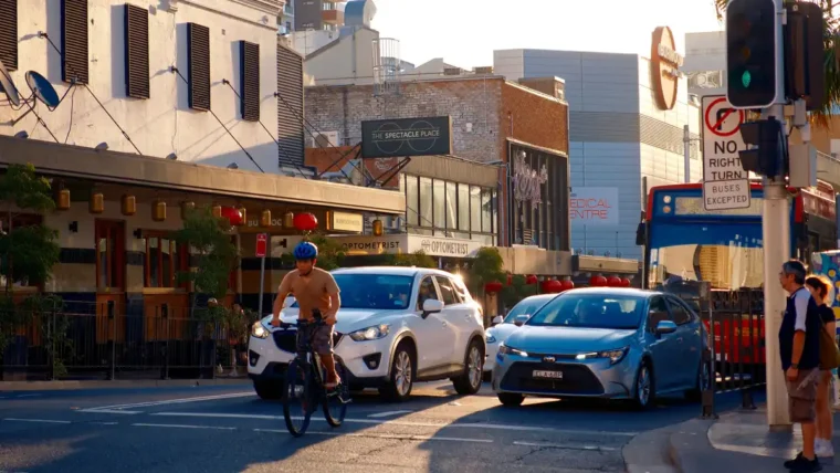 A commuter cycling to work past city traffic