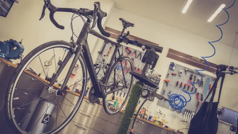 A bicycle in a workshop with a track pump and tools