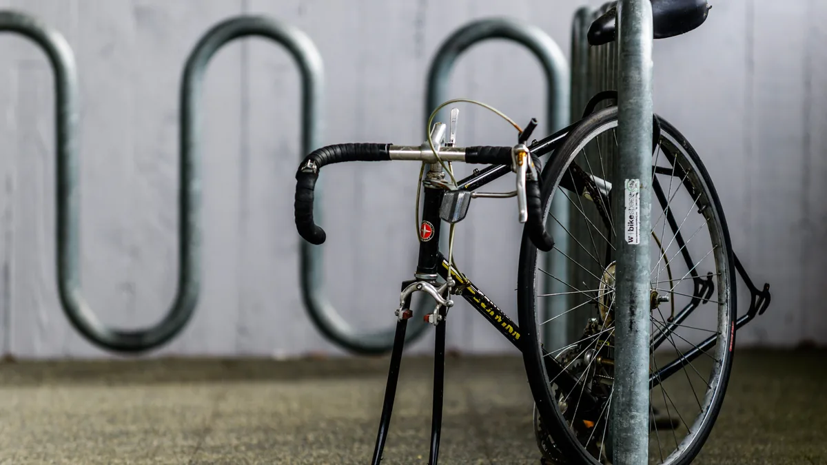 A bicycle secured to a metal cycle rack