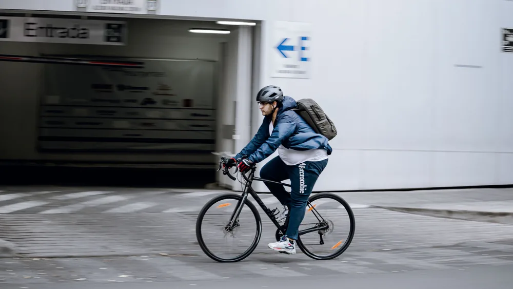 A new commuter with helmet and backpack setting off