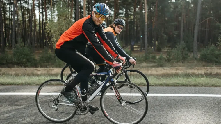 Two cyclists riding road bikes side by side on a country road