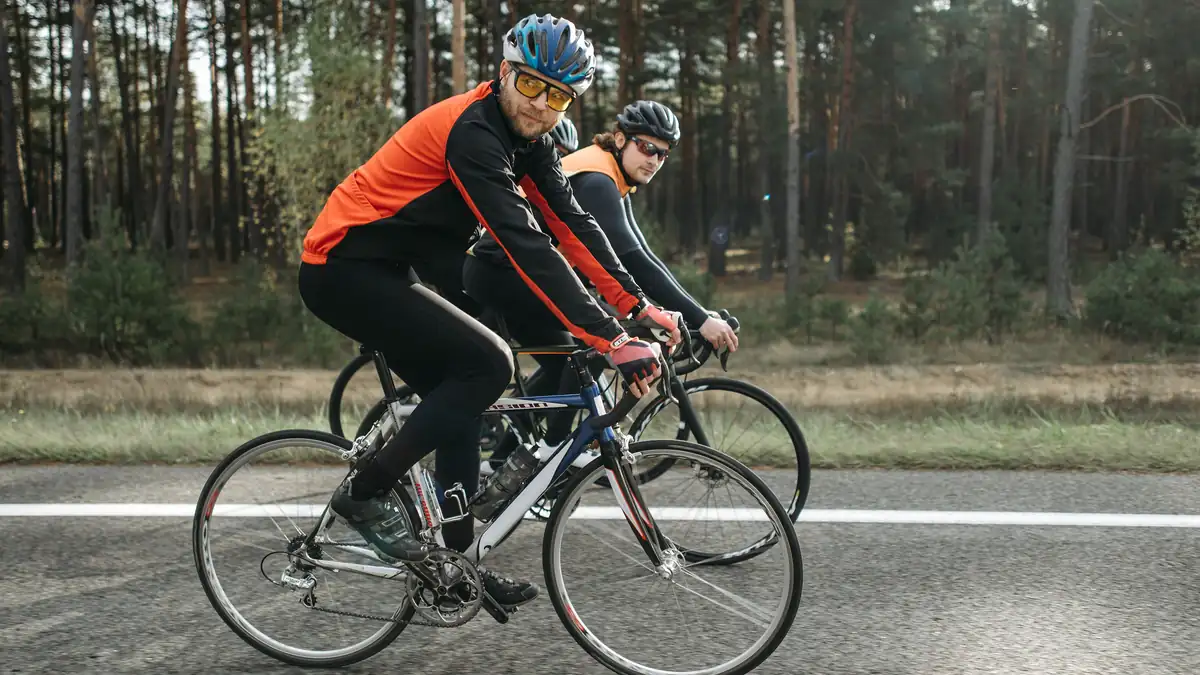 Two cyclists riding road bikes side by side on a country road