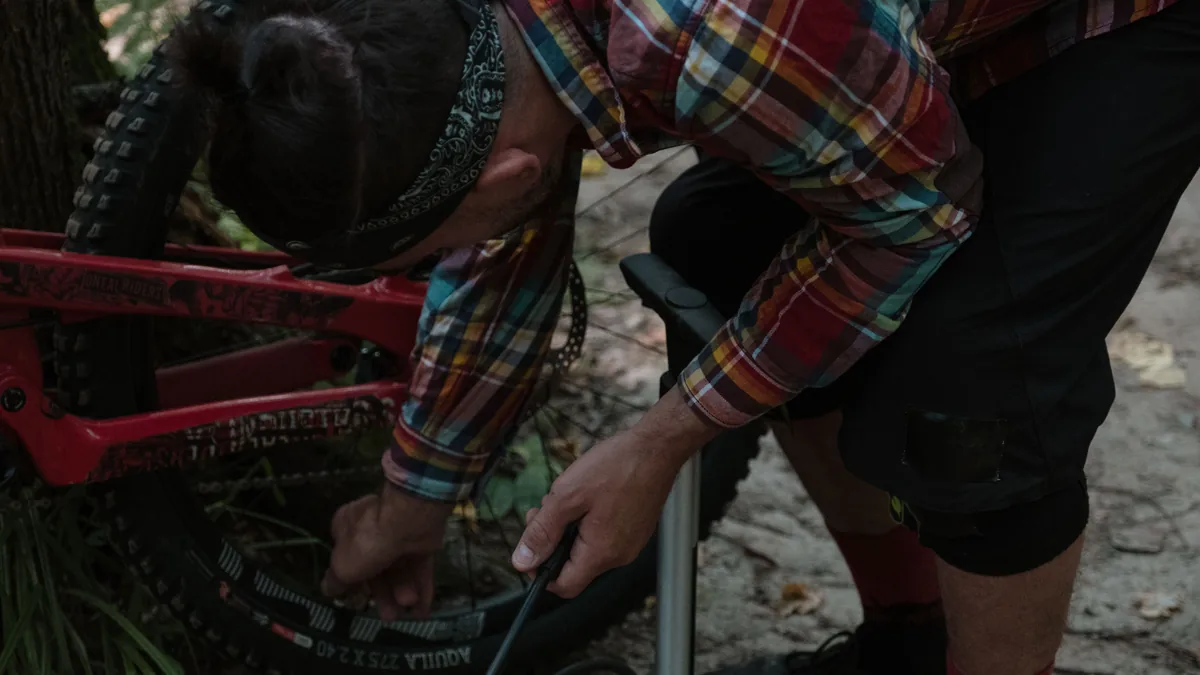 Commuter inflating a bicycle tyre with a floor pump