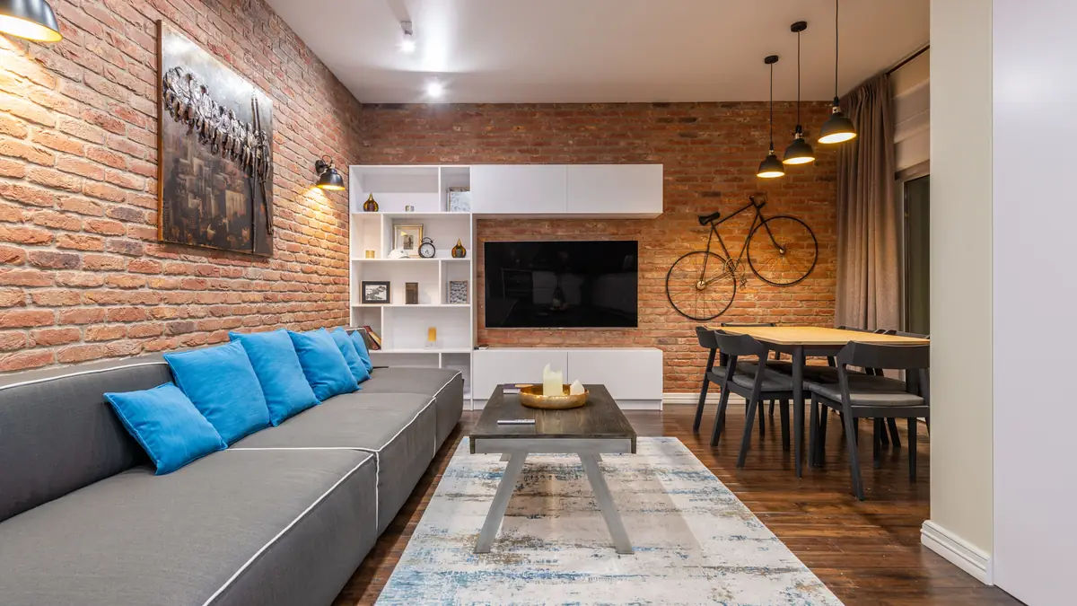 A bicycle stored on a wall-mounted hook in a home hallway