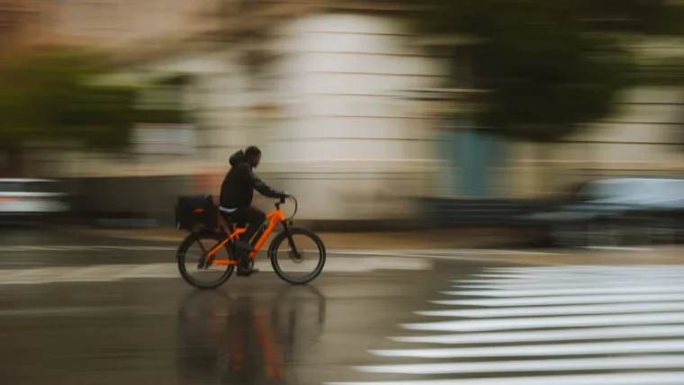 A commuter cyclist riding a bike with mudguards on a wet UK road