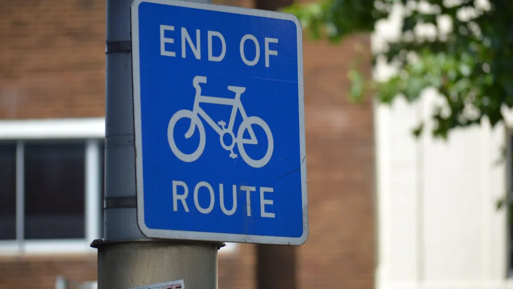 NCN cycle route signpost alongside a quiet UK road