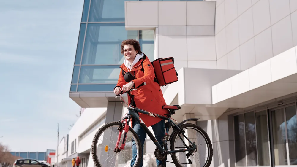 An employee locking their bike outside a modern office building