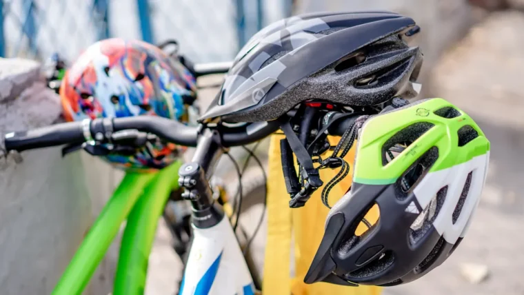 Cycle helmets hanging from the handlebars of parked bikes