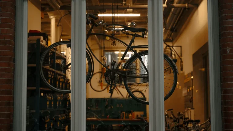 A bicycle hanging in the window of a bike repair shop